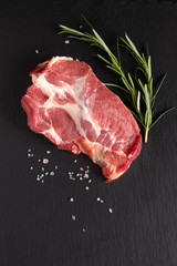 Food organic Fresh Crude Pork Neck on black slate stone with copy space