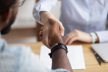 Close up view handshaking hands after successful interview and negotiation