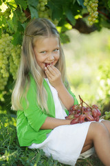 Fototapeta premium Child with grapes in nature 