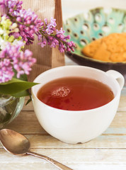 Tea and blooming lilac, petal in a cup