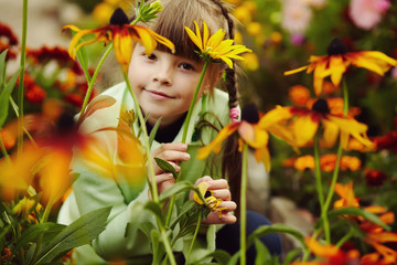 cute little girl in the garden with flowers