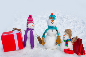 Snowman - father, mother and snowman - baby surprise outdoor. Greeting snowman family, parenthood concept. Delivery gifts.