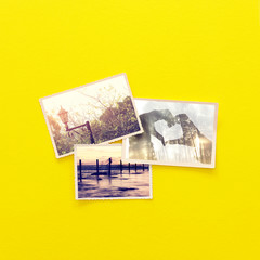 top view of photos album over yellow wooden background. top view flat lay