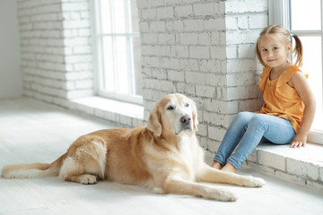 Child girl with dog at home 