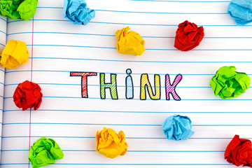 The word Think on notebook sheet with some colorful crumpled paper balls around it
