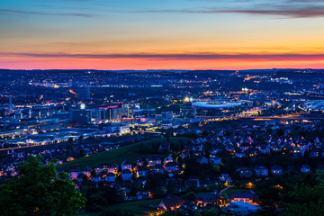 Germany, Magical illuminated skyline of houses downtown stuttgart bad canstatt and famous arena from above after sunset