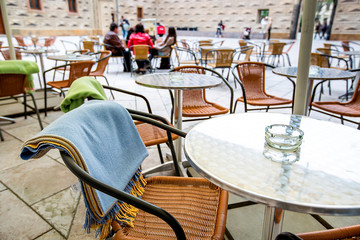 Cozy chairs with a warm blanket with a coffee table on the street. Cafe-restaurant on the terrace.