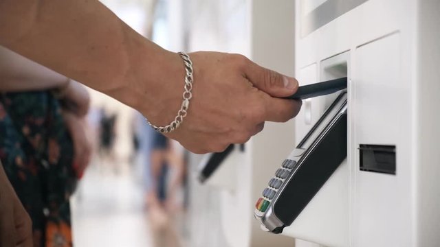 a young man buys a telephone in a contactless way in a self-service machine. men pay by phone. close up