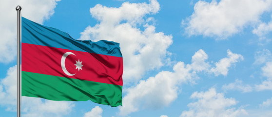 Azerbaijan flag waving in the wind against white cloudy blue sky. Diplomacy concept, international relations.