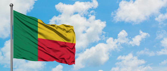 Benin flag waving in the wind against white cloudy blue sky. Diplomacy concept, international relations.