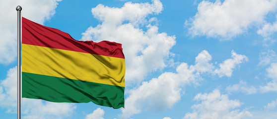 Bolivia flag waving in the wind against white cloudy blue sky. Diplomacy concept, international relations.