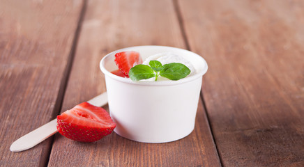 Vanilla ice cream with waffles, mint leaf, strawberries and blueberries on the wooden table