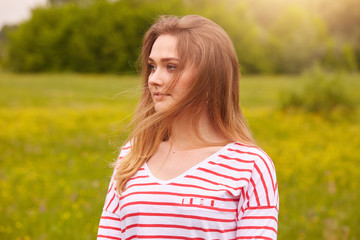 Profile of cute girl posing outdoors, beautiful woman spending summer holiday in meadow, happy...
