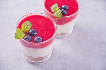 Bowls of breakfast healthy muesli with blueberry, strawberry and yogurt.