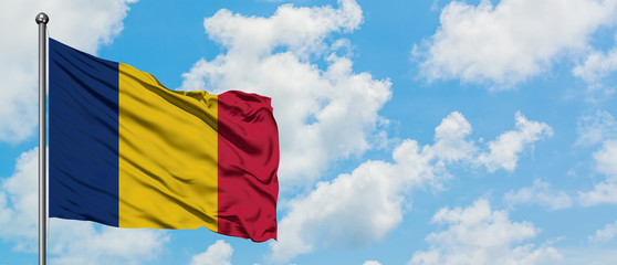 Chad flag waving in the wind against white cloudy blue sky. Diplomacy concept, international...