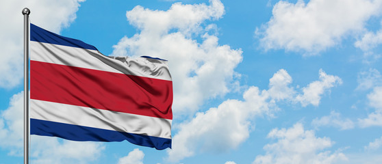 Costa Rica flag waving in the wind against white cloudy blue sky. Diplomacy concept, international relations.