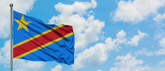 Congo flag waving in the wind against white cloudy blue sky. Diplomacy concept, international relations.