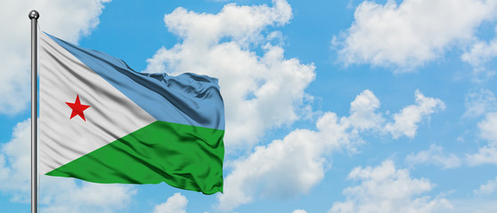 Djibouti flag waving in the wind against white cloudy blue sky. Diplomacy concept, international relations.