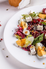 Fresh mixed salad in a bowl on a white background
