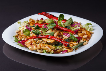Mexican salad with hot pepper chiken fillet lettuce on plate