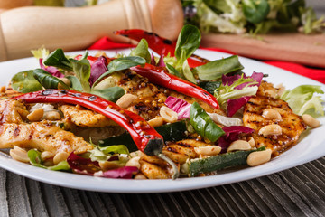 Mexican salad with hot pepper chiken fillet lettuce on plate