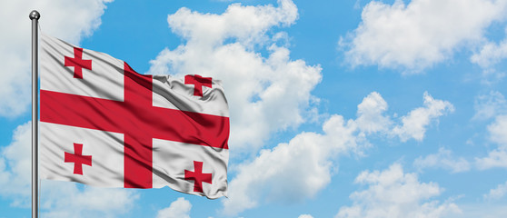 Georgia flag waving in the wind against white cloudy blue sky. Diplomacy concept, international relations.