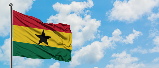Ghana flag waving in the wind against white cloudy blue sky. Diplomacy concept, international relations.