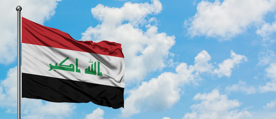 Iraq flag waving in the wind against white cloudy blue sky. Diplomacy concept, international relations.