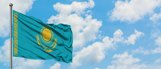Kazakhstan flag waving in the wind against white cloudy blue sky. Diplomacy concept, international relations.