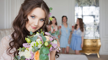 Fototapeta na wymiar Young beautiful brunette at a bachelorette party. A young woman with a bouquet of flowers,