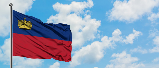 Liechtenstein flag waving in the wind against white cloudy blue sky. Diplomacy concept, international relations.