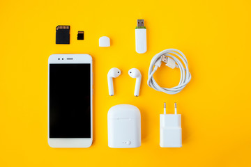 Mobile kit with smartphone, wireless headphones and chargers.