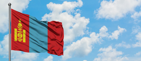 Mongolia flag waving in the wind against white cloudy blue sky. Diplomacy concept, international relations.