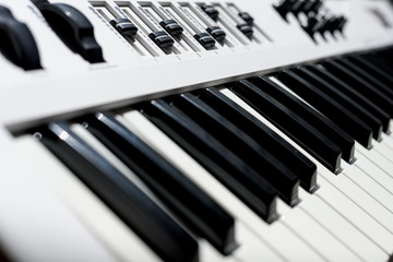 Close up of keyboard synthesizer instrument. Black and white keys of piano and controls.