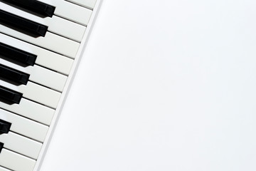 Fototapeta na wymiar Top view of keyboard instrument on white background with copy space. Black and white keys of piano.