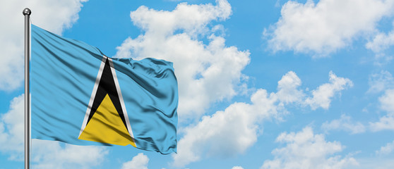 Saint Lucia flag waving in the wind against white cloudy blue sky. Diplomacy concept, international relations.