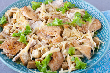 Delicious salad with chicken and crackers on a plate. Caesar salad.