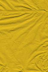 Transparent yellow plastic wrap on the black background. Plastic shopping bag texture. Reusable trash and waste.