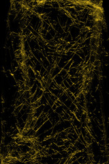 Transparent yellow plastic wrap on the black background. Plastic shopping bag texture. Reusable trash and waste.