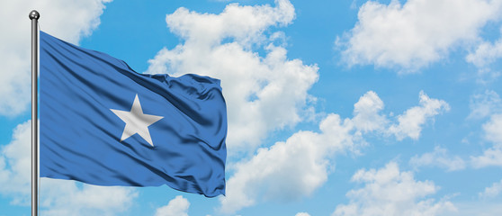 Somalia flag waving in the wind against white cloudy blue sky. Diplomacy concept, international relations.