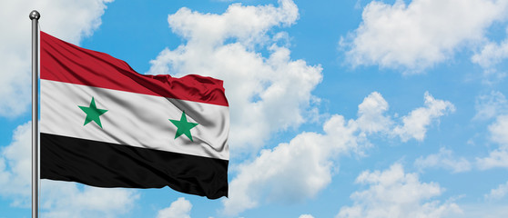 Syria flag waving in the wind against white cloudy blue sky. Diplomacy concept, international...