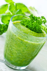 Glass of green smoothie with herbs