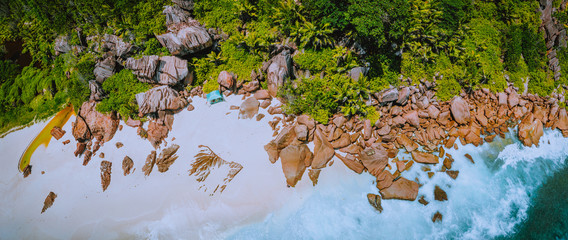 Aerial top panoramic view of granite rocks and tropical beach on the Petite Anse beach, La Digue,...