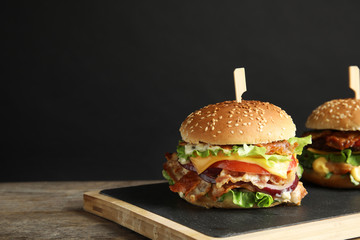Tasty burger with bacon served on table. Space for text