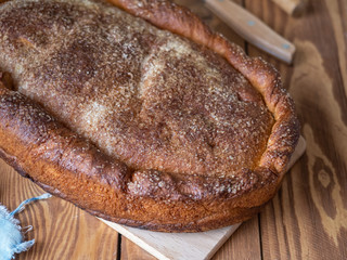 Freshly baked homemade pie on a wooden plank table, shot from close up with blurred focus.