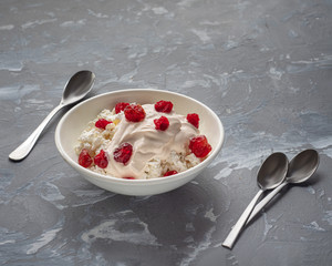A plate of homemade cottage cheese with sour cream and dried cherries for a light breakfast.