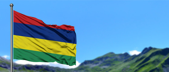 Mauritius flag waving in the blue sky with green fields at mountain peak background. Nature theme.