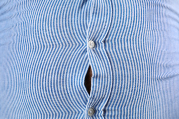 Overweight man with large belly in tight shirt , closeup
