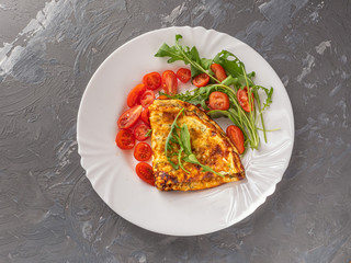 Light omelette breakfast with fresh herbs and chopped cherry tomatoes