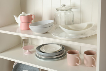 White shelving unit with set of dishware